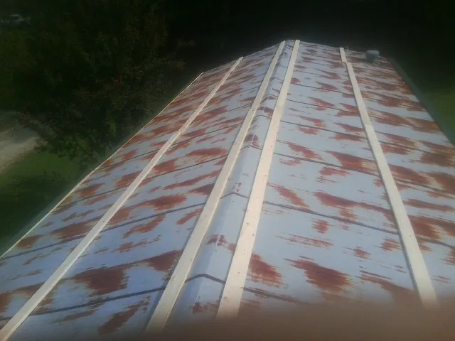 Rusted metal roof panels with new wood purlins before replacement — Storm Damage Roof Repair in Barton by Roofing Brothers